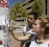 Dos estudiantes observan anuncios de pisos y habitaciones en el campus Unamuno de Salamanca.