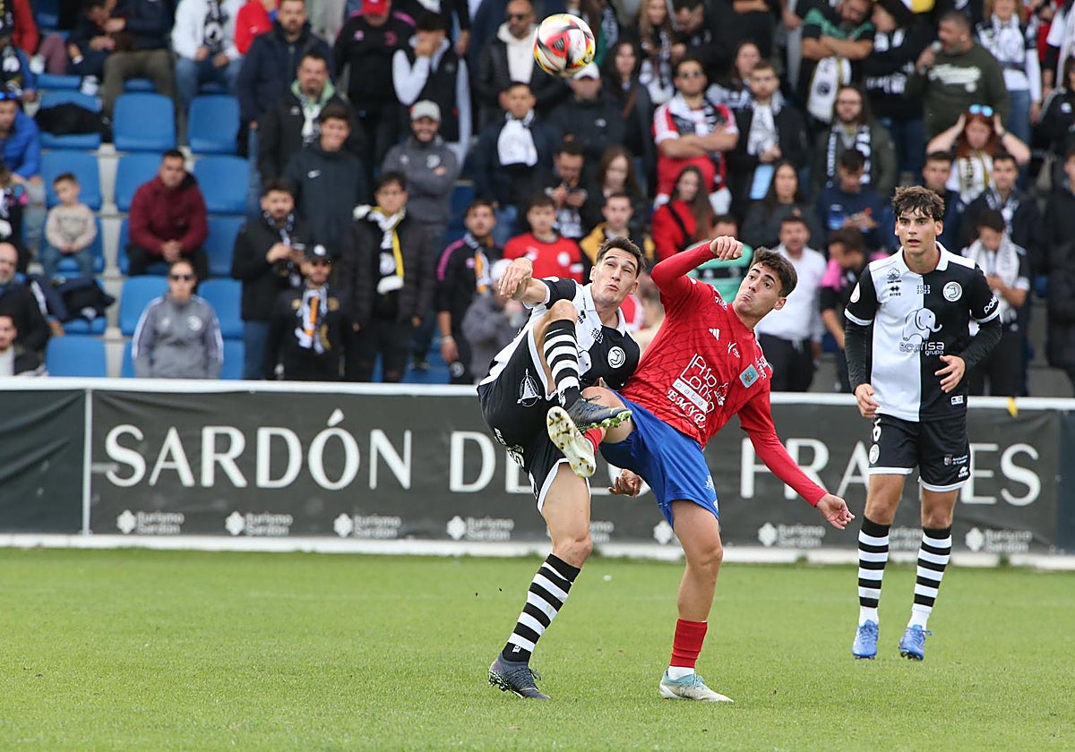 Un jugador de Unionistas pugna por el balón con otro del Tarazona