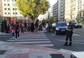 Un agente de la Policía Local vigila el aparcamiento a la puerta de un colegio.