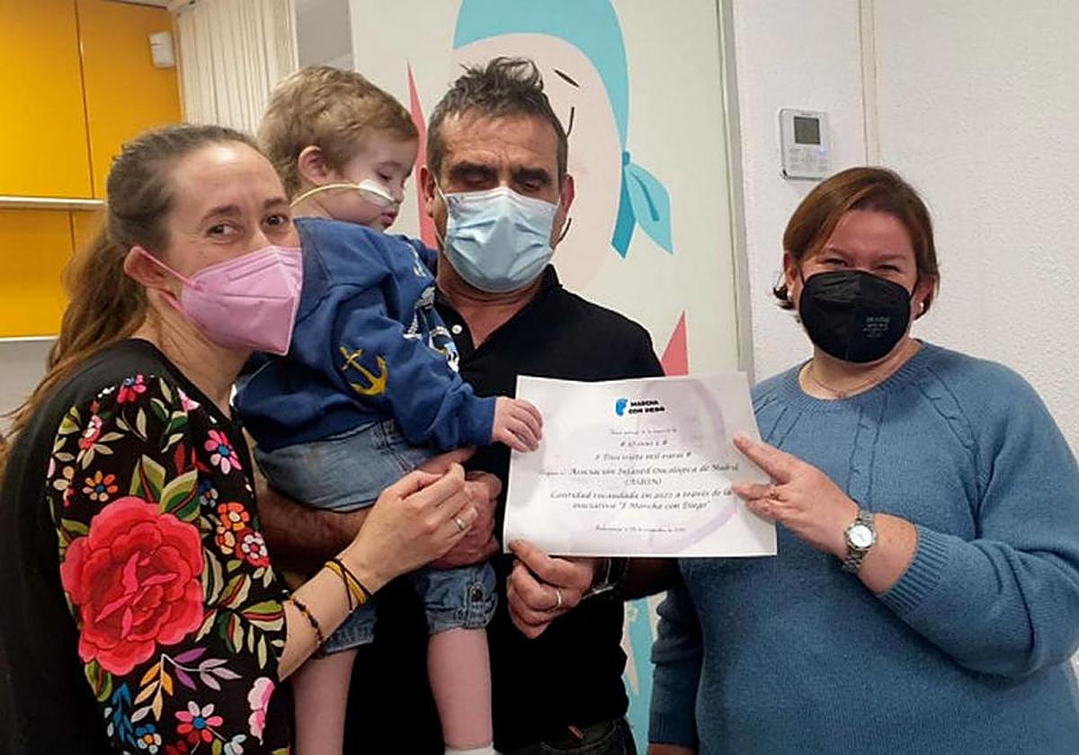 Diego, en los brazos de su padre, junto a su madre y una de las promotoras de esta iniciativa.