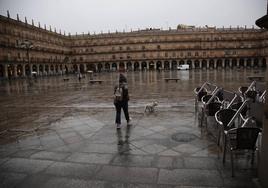 Gente camina bajo la lluvia en la Plaza Mayor