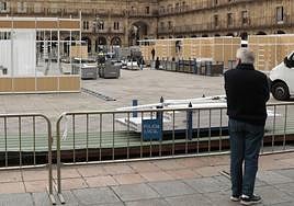 Una persona observa en la Plaza Mayor el montaje de la reciente Feria del Libro.