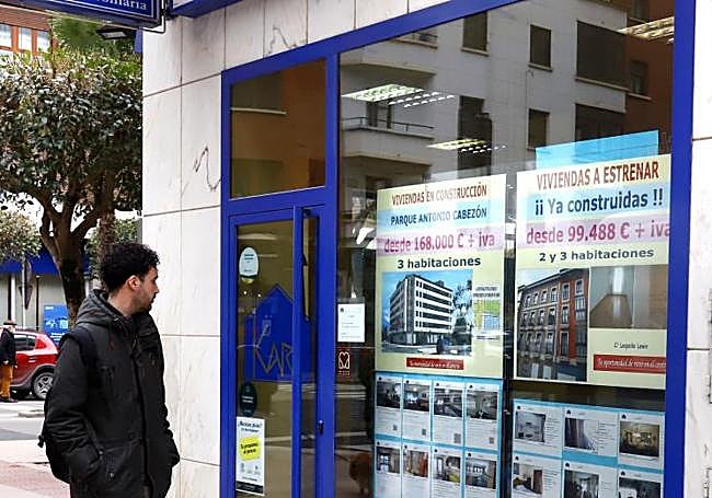 Una persona observa el escaparate de una inmobiliaria