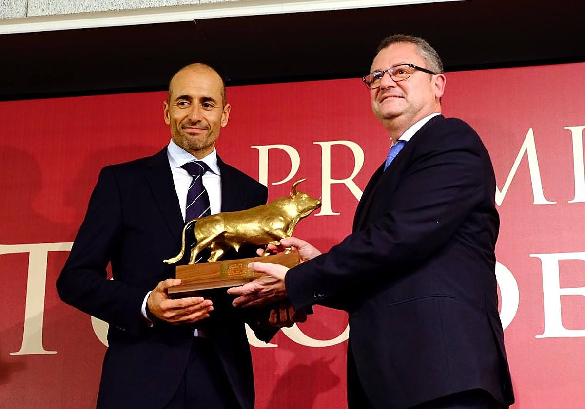 El consejero entrega el premio al ganadero galardonado.