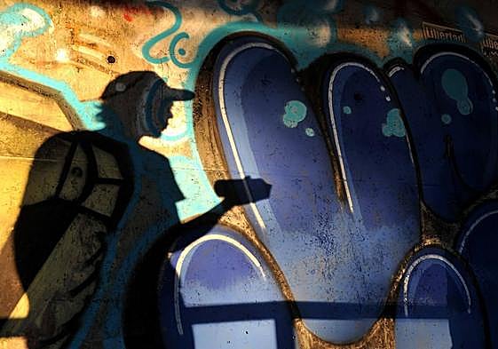 Un grafitero, preparado para realizar su obra en una pared.