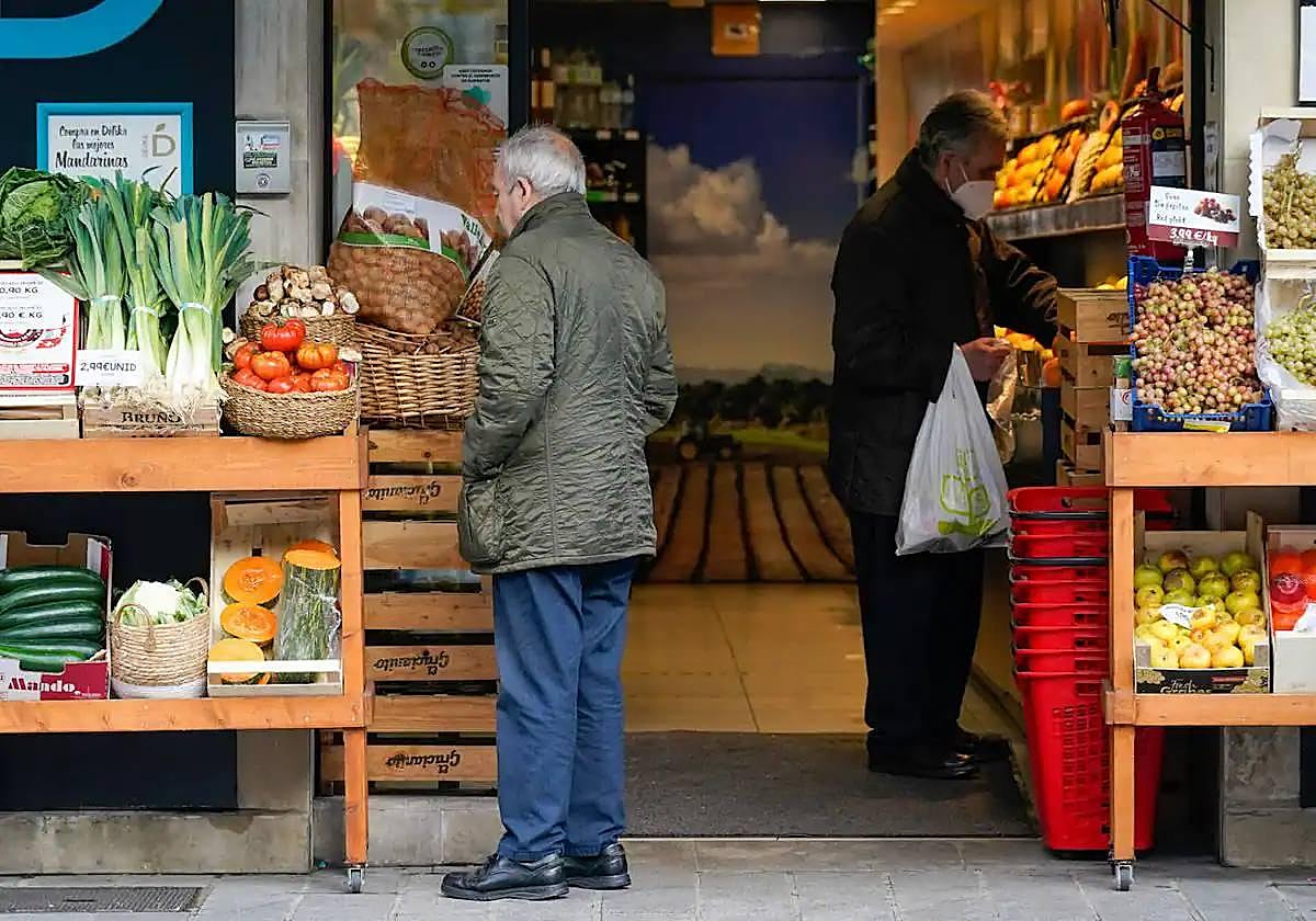 Clientes comprando en una frutería.