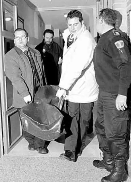 Agentes cargando con el cuerpo de la víctima