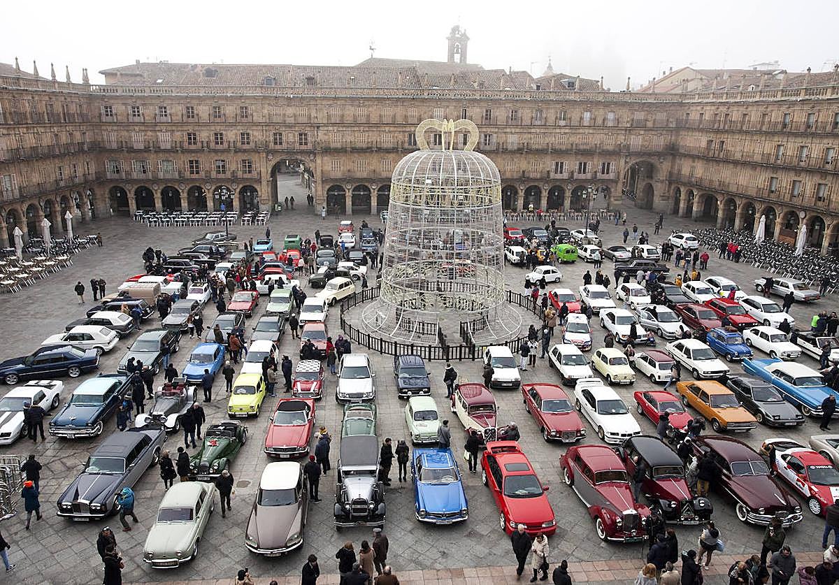 Imagen principal - Los 180 participantes en la Plaza Mayor y dos vehículos entrando ante la mirada del Guardia Urbano.
