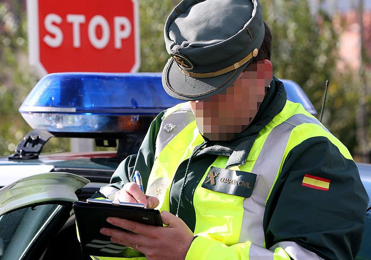 Un agente de la Guardia Civil tramita una multa.