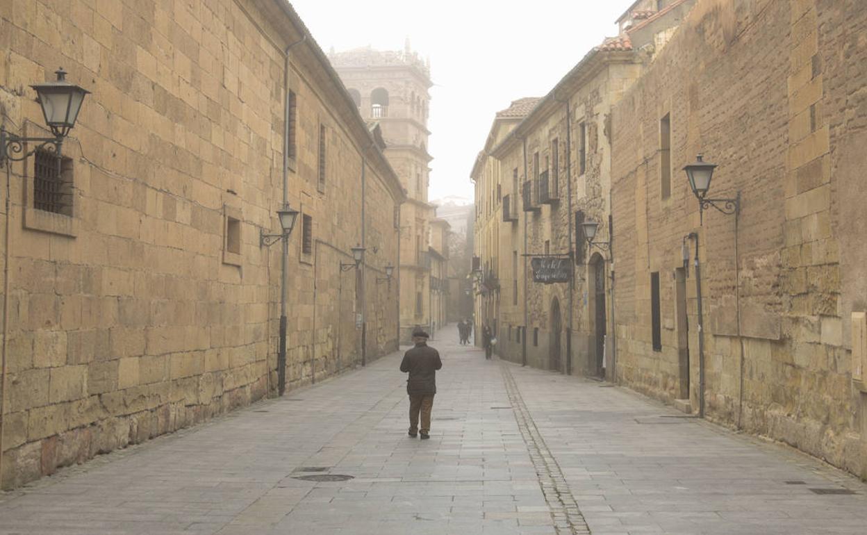 Un viandante caminando hacia el Palacio de Monterrey en la calle de la Compañía de Salamanca.