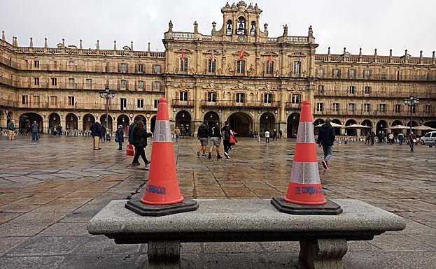 Los operarios instalan los bancos de piedra de la Plaza Mayor.