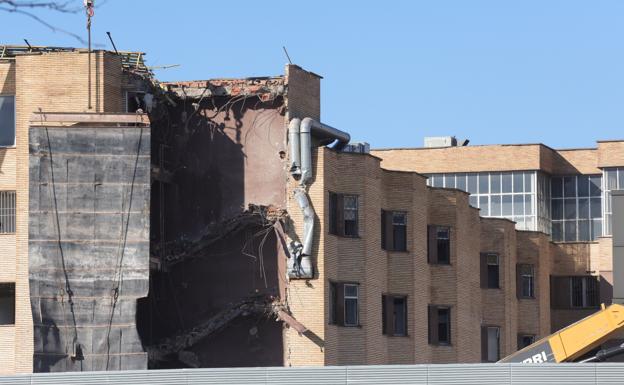 Imagen principal - Un larguísimo brazo mecanizado amenaza la estructura del edificio más alto del viejo hospital