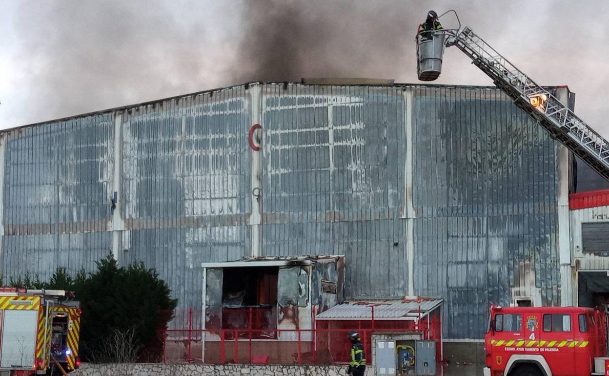 Los bomberos de Palencia actuando contra el incendio declarado en una nave en Dueñas.