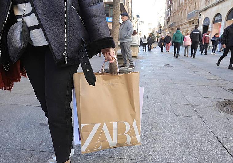 Mujer caminando con bolsas en la calle Toro.