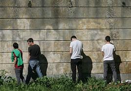 Varios jóvenes orinando junto a un muro en la zona del Puente Romano.
