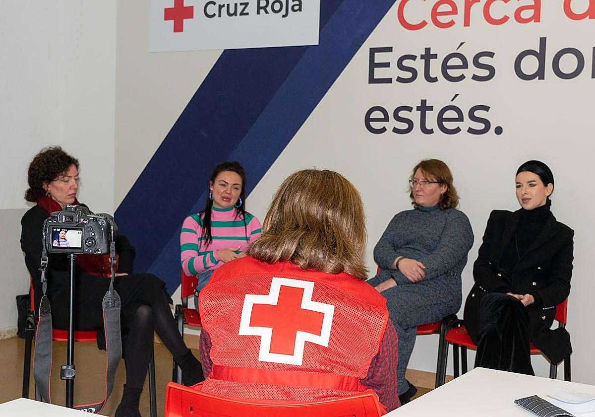 Mujeres ucranianas charlan con una voluntaria de Cruz Roja.
