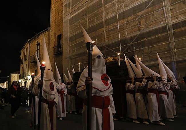 Una procesión a su paso por la Casa de las Conchas en obras.