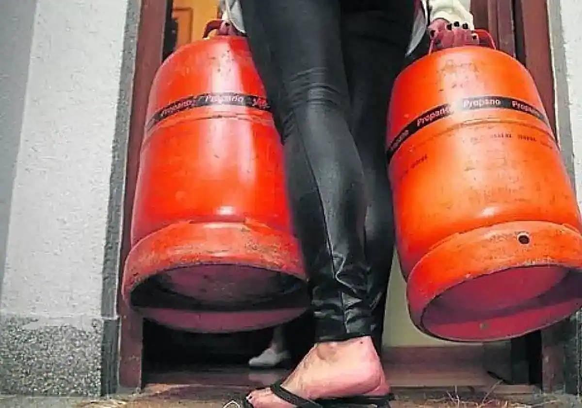 Una mujer con dos bombonas de butano.