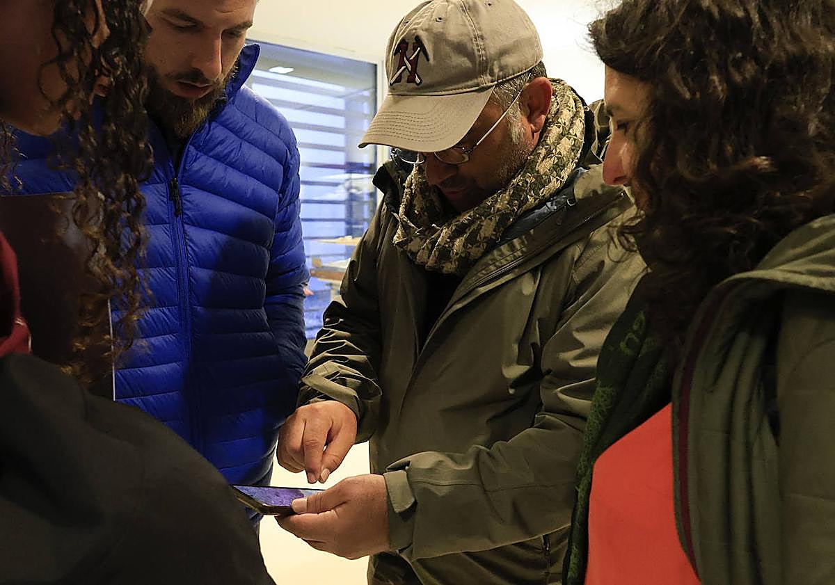 Imagen principal - Galán, enseñando una huella en su móvil, con la colaboradora de Salamancahoy, Ana Carlos, y el auditorio durante su charla.