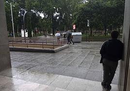 Una mujer espera a que deje de llover.