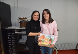 Esther Sánchez (derecha) enseñando el libro junto a su madre Raquel García (izquierda)