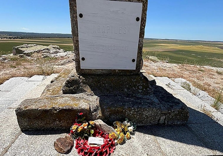 El monolito de la batalla de Arapiles y, abajo, el mensaje de paz junto a una corona de flores.
