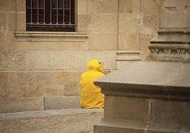 Una persona con un chubasquero para protegerse de la lluvia