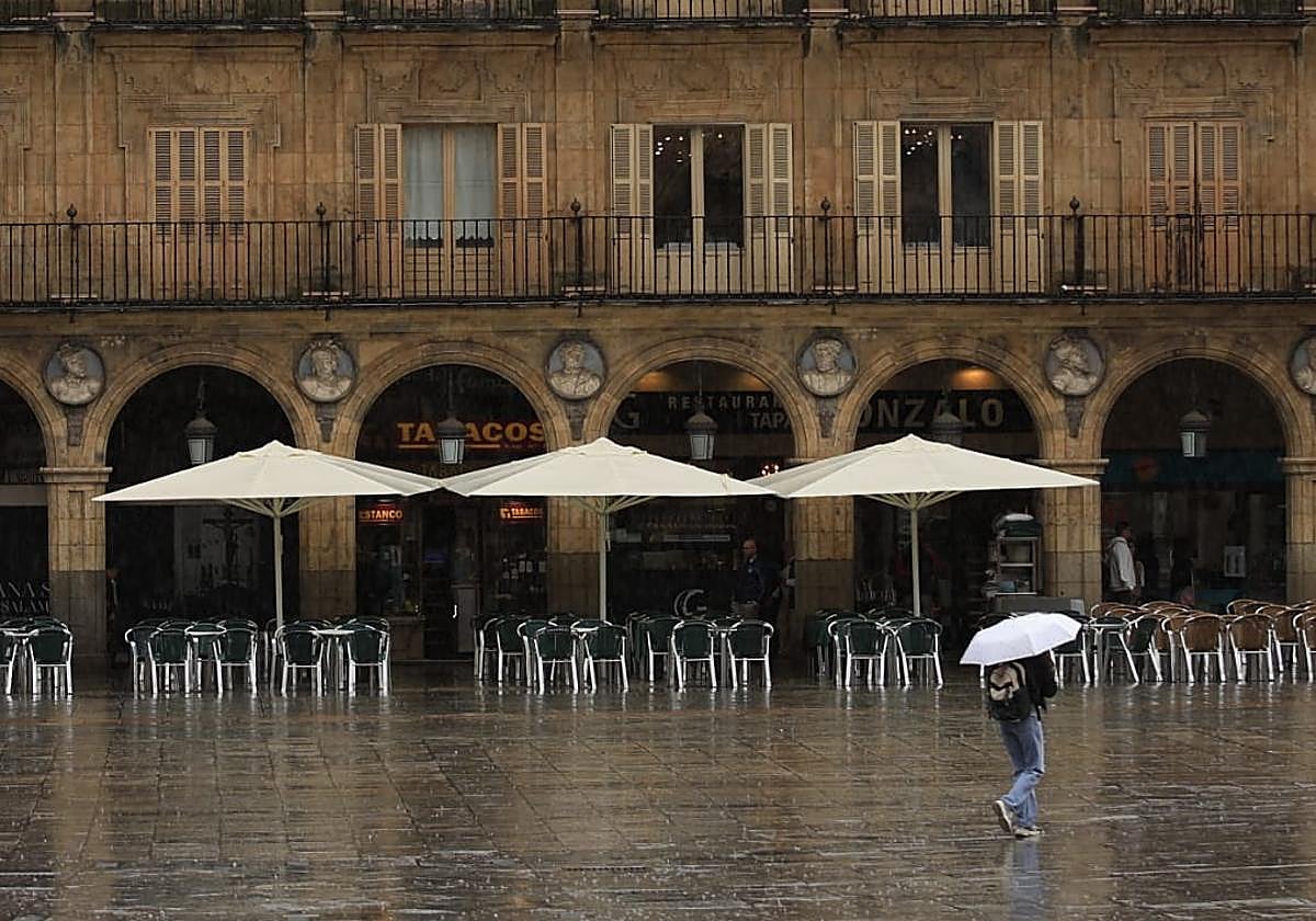 Una persona pasea por la Plaza Mayor de Salamanca este martes con lluvia.