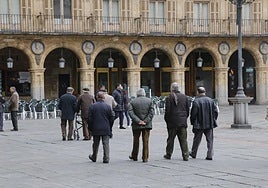 Foto de archivo de varias personas mayores paseando por la Plaza Mayor
