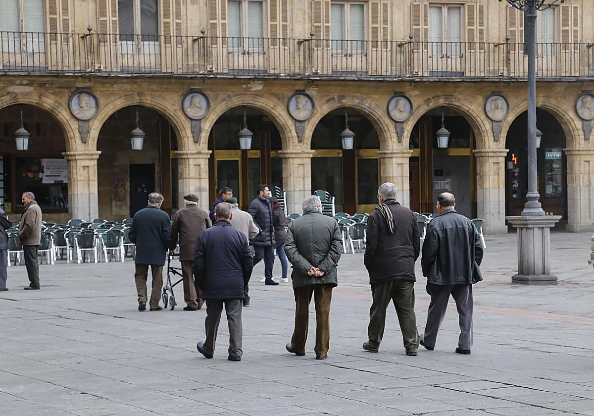 Foto de archivo de varias personas mayores paseando por la Plaza Mayor