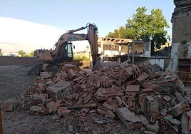 Maquinaria derribando las construcciones ruionosas del solar.