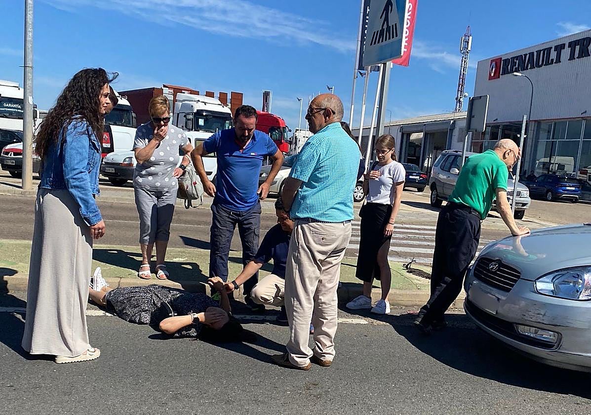 Personas socorriendo a la mujer, víctima del accidente.