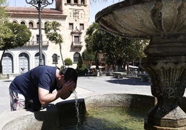 Un joven se refresca en la fuente de la Plaza de los Bandos de Salamanca para mitigar el calor.