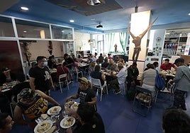 Numerosas personas comen en el Comedor de los Pobres