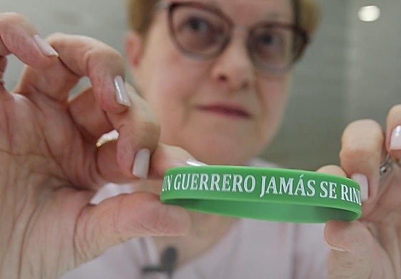 Carmen enseña la pulsera con su mensaje de fuerza.