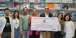 Ana del Fraile hace entrega del cheque en el laboratorio dirigido por la investigadora Esther Castellano.