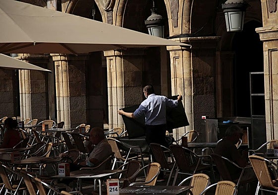 Un camarero preparando una mesa en la Plaza Mayor