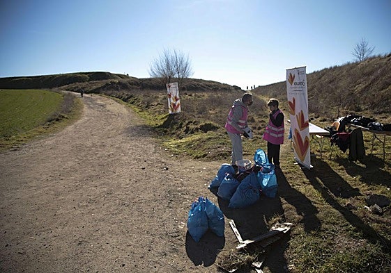 Voluntarios recogen basura en el monte.