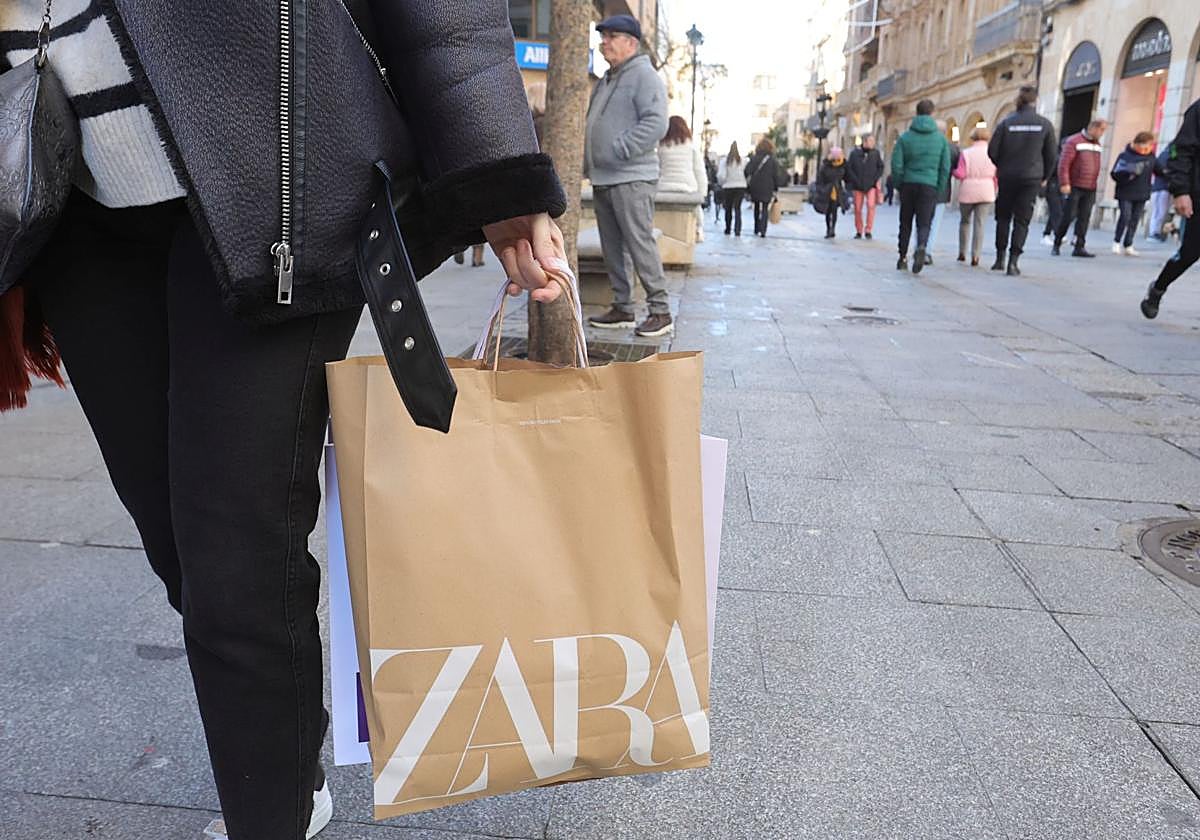 Una personas pasea con una bolsa de Zara en una céntrica calle de Salamanca.