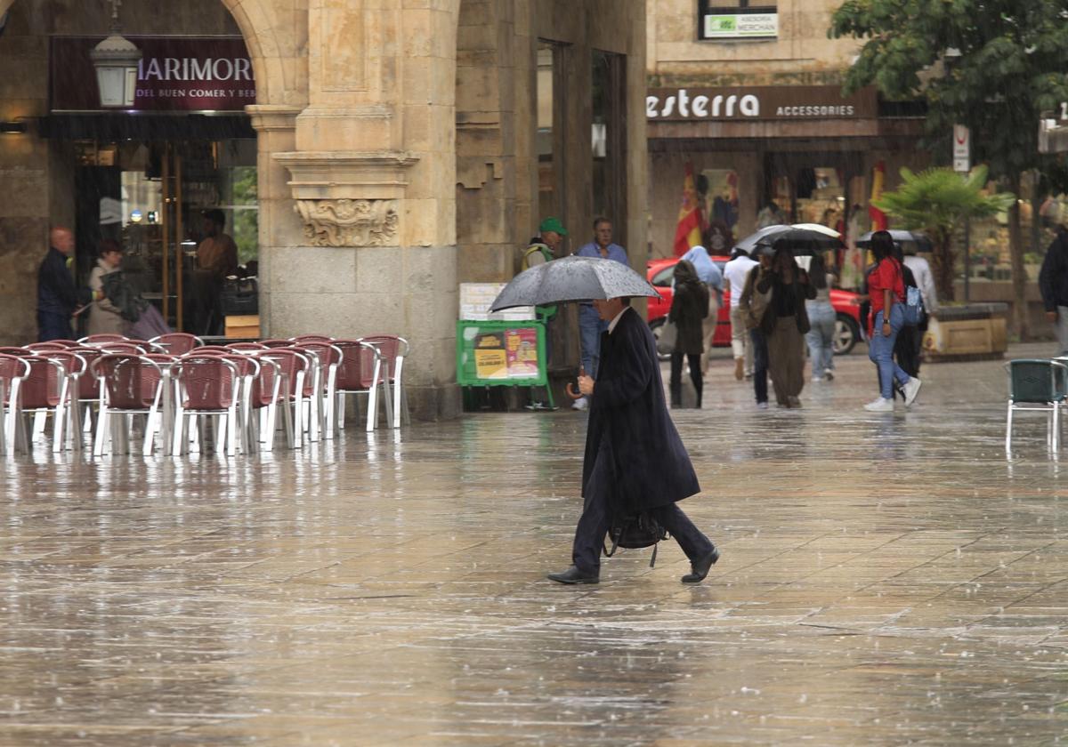 Un viandante caminando por la Plaza Mayor de Salamanca un día de lluvia.