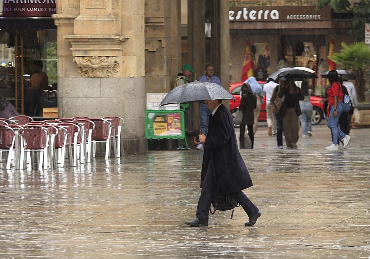 Una persona pasa por la Plaza Mayor de Salamanca en un día de lluvia.