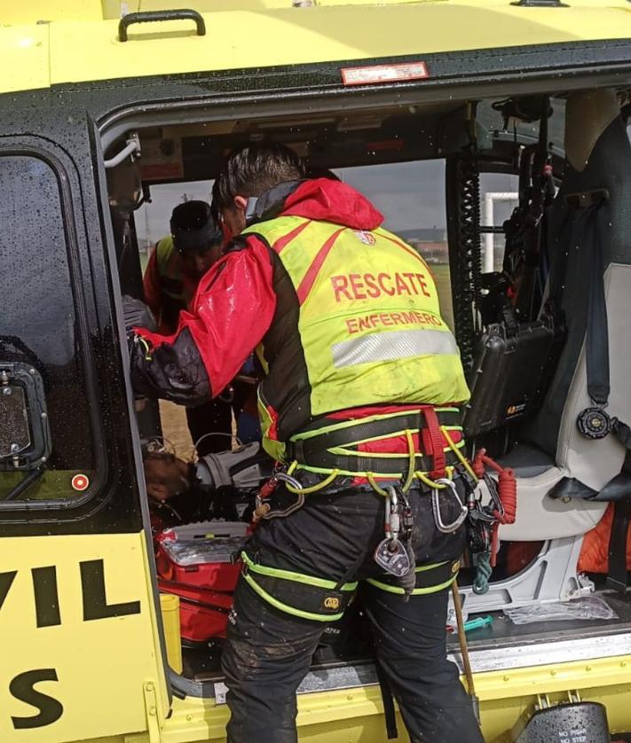 Imagen secundaria 2 - Lugar donde estaba el herido, helicóptero en el que se le ha evacuado y enfermero del operativo de rescate.