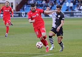 Un jugador de Osasuna B trata de controlar el balón ante la oposición de Vergés