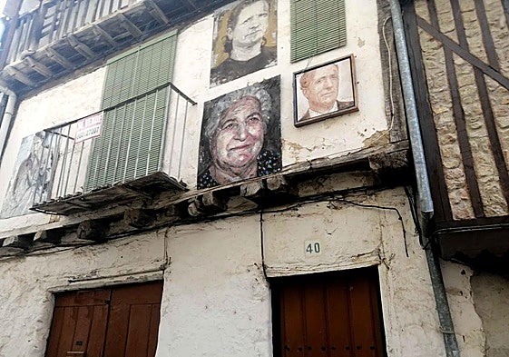 Fachada de la vivienda en venta, adornada con retratos de vecinos.