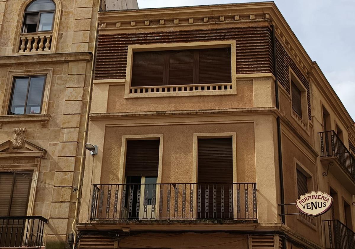 Imagen principal - La característica fachada del edificio, detalle del rótulo y vallado de las obras.