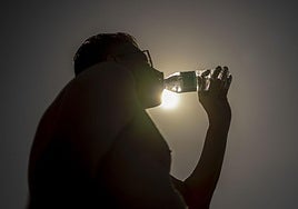 Una persona bebe agua en una calurosa tarde en una imagen de archivo.