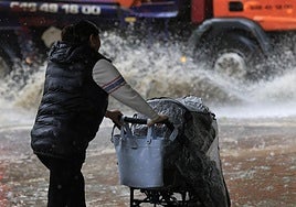 Una mujer con un carrito de bebé en plena tormenta.