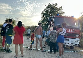 Bañistas en la zona donde se busca al joven desaparecido en Alba de Tormes junto a un campeón de bomberos de la Diputación de Salamanca.