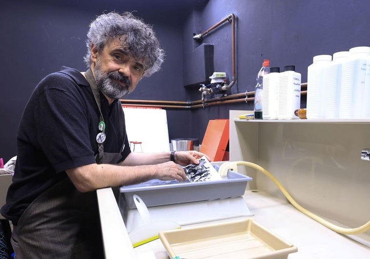 El artista Claudio de la Cal revelando una fotografía en su laboratorio Artística Marciana.