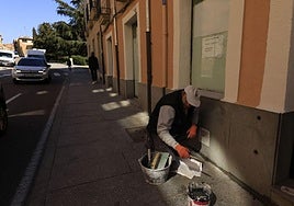 Trabajador pintando una fachada en la calle San Pablo.
